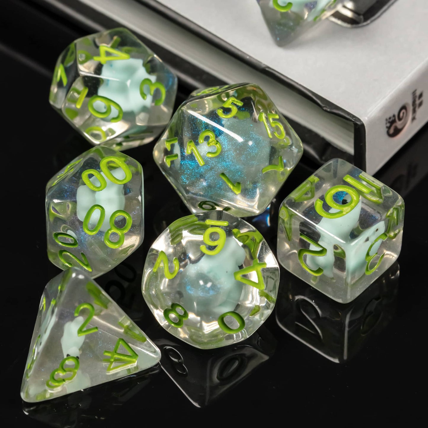 Transparent Dino Dice stacked on reflective black surface highlighting bright green engraved numbers