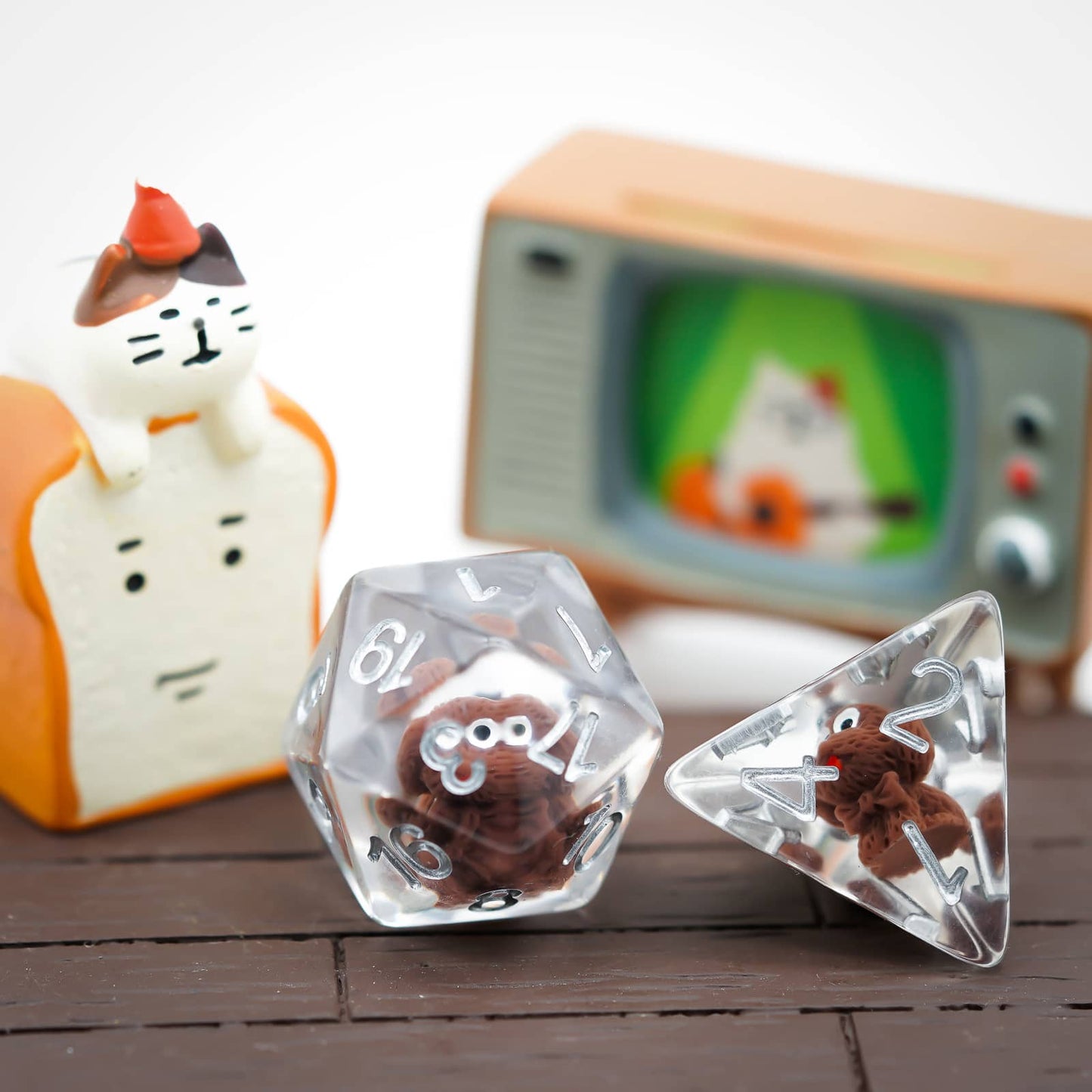 Close-up of Transparent Doggo Dice Set D20 and D4 showing cute brown dog miniatures in clear resin