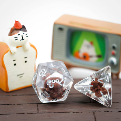 Close-up of Transparent Doggo Dice Set D20 and D4 showing cute brown dog miniatures in clear resin