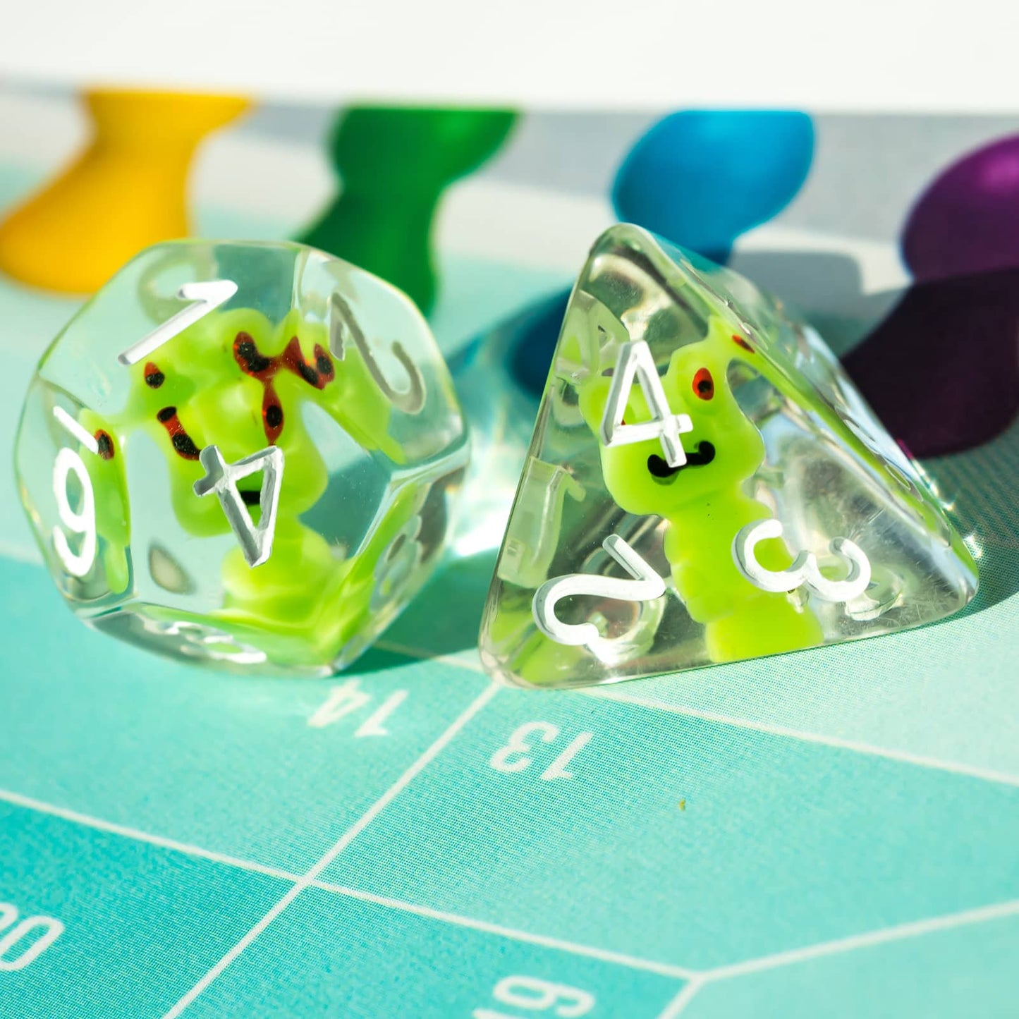 Close-up of Transparent Froggo D20 and D4 dice with playful green frogs in clear resin