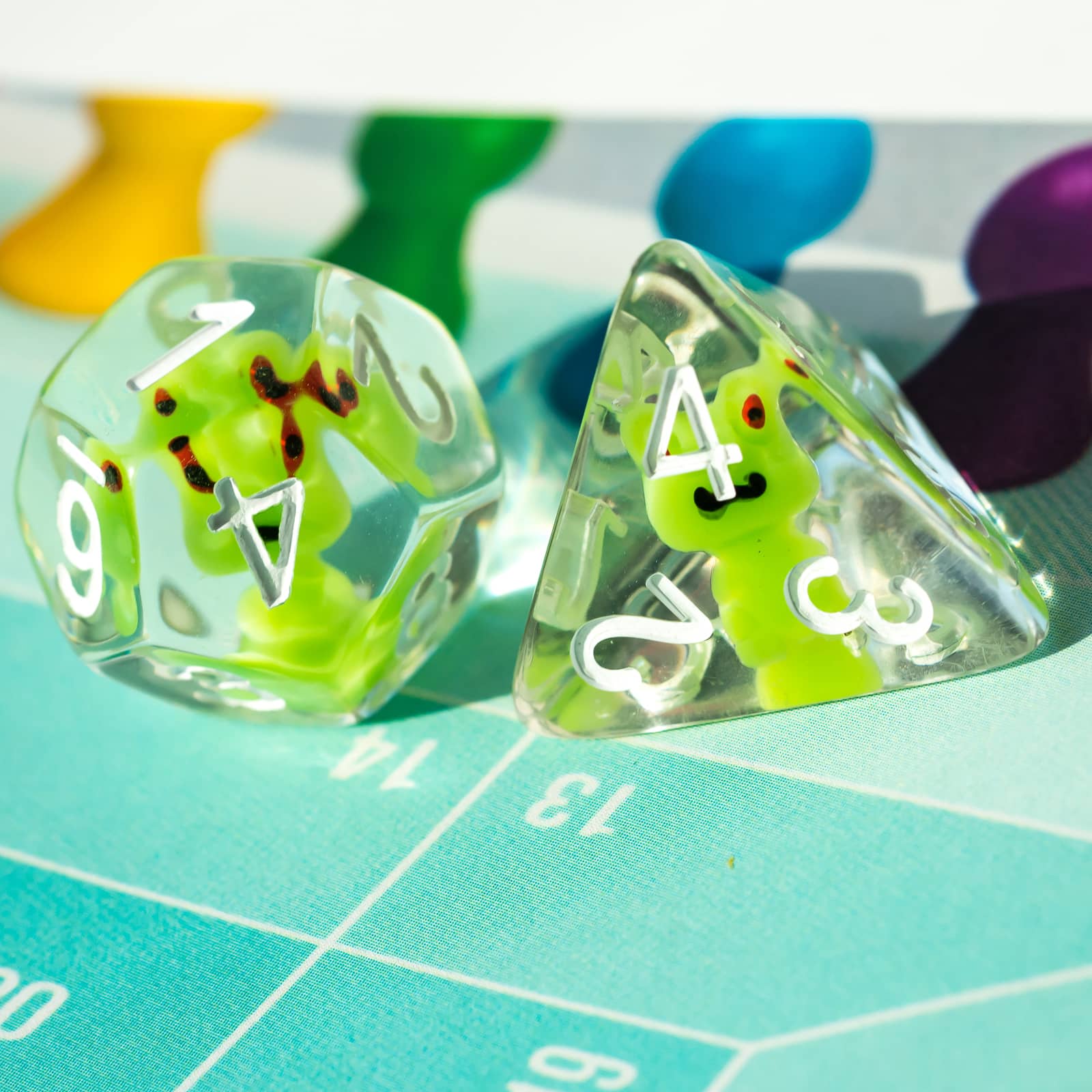 Close-up of Transparent Froggo D20 and D4 dice with playful green frogs in clear resin