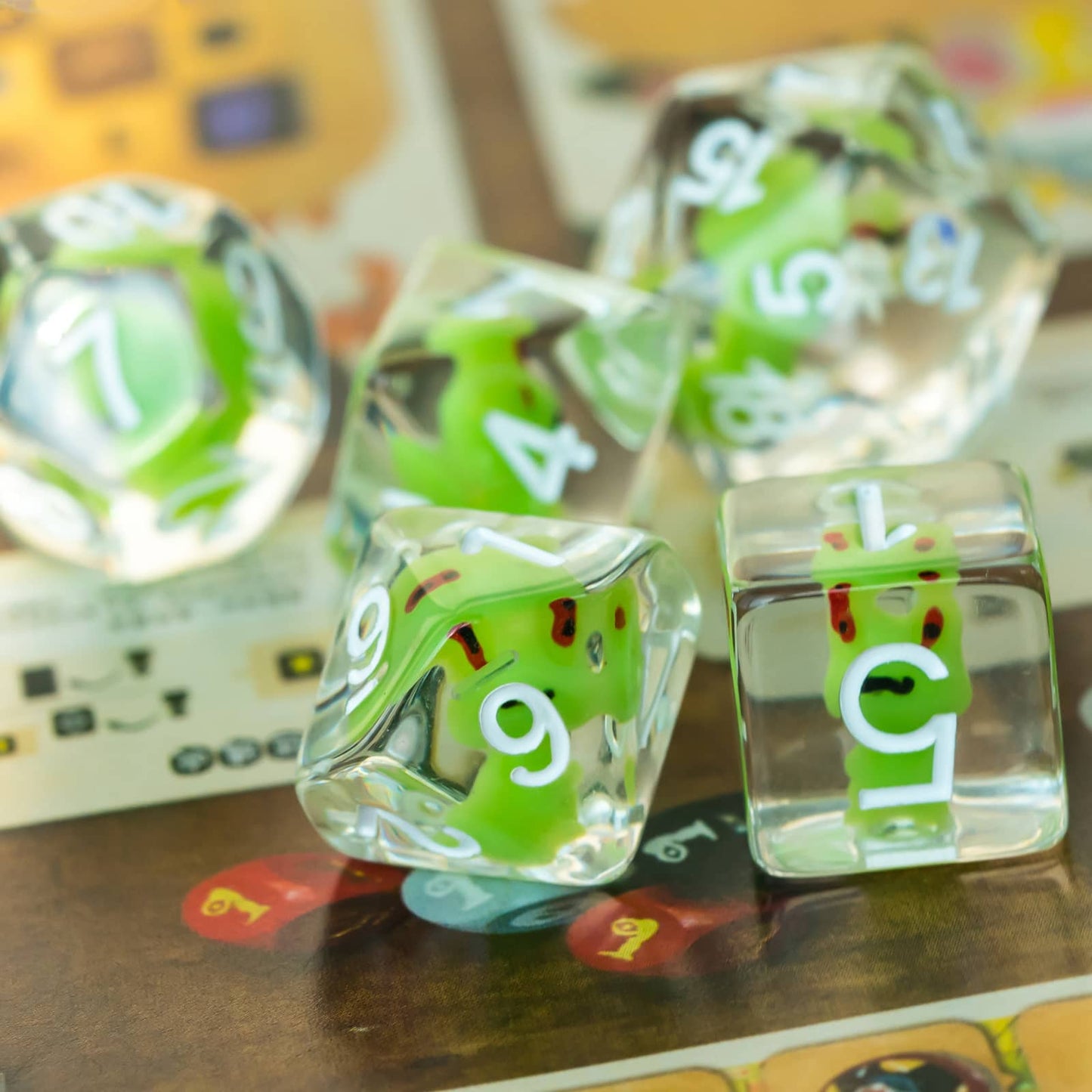Reflective tabletop shot of Transparent Froggo Dice Set emphasizing frog detail and crystal clarity