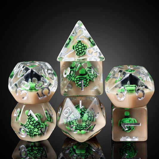 Transparent green turtle dice set with turtle figurines inside clear resin, silver numbers, on black background