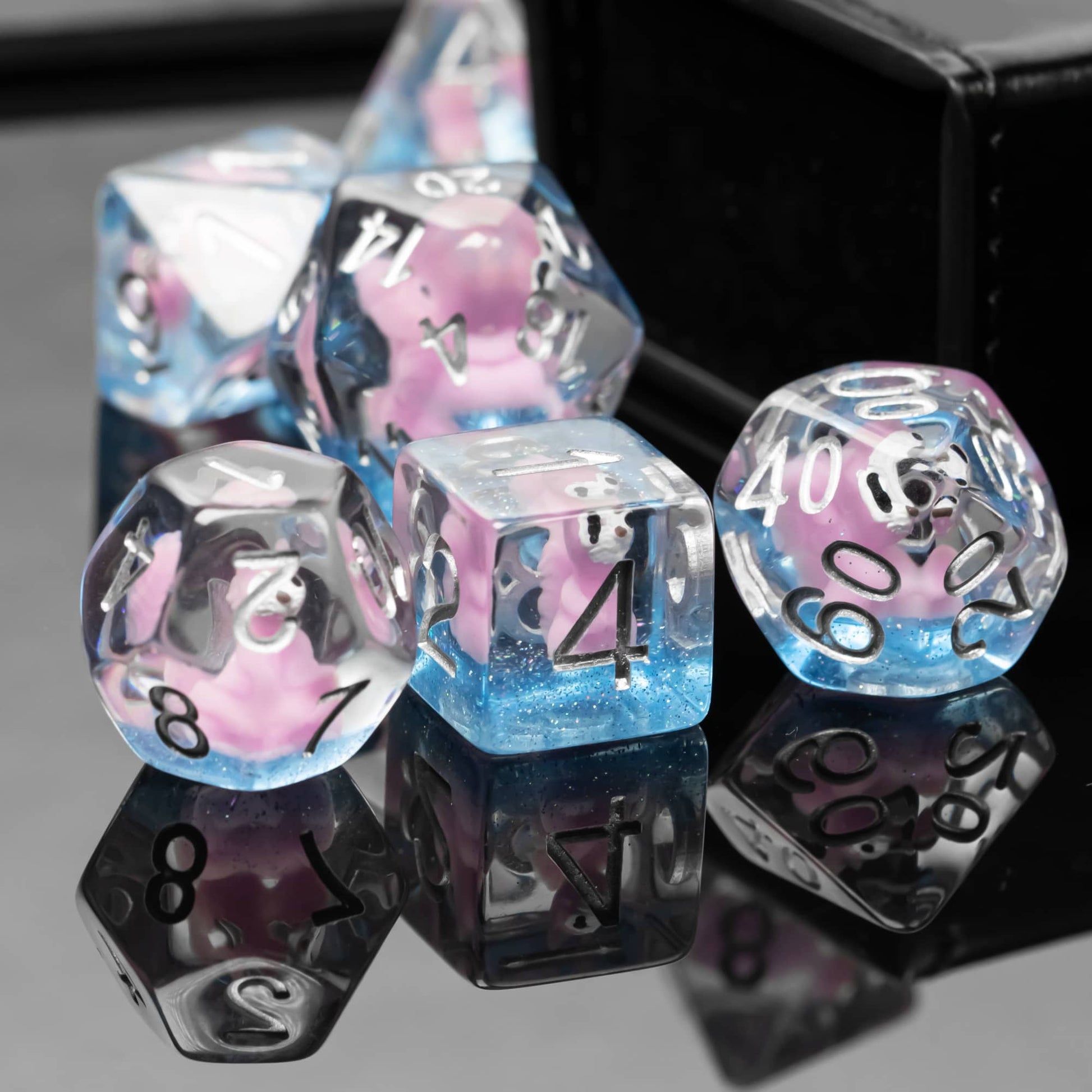 Group of Transparent Pink Squirrel Dice arranged together on black reflective surface