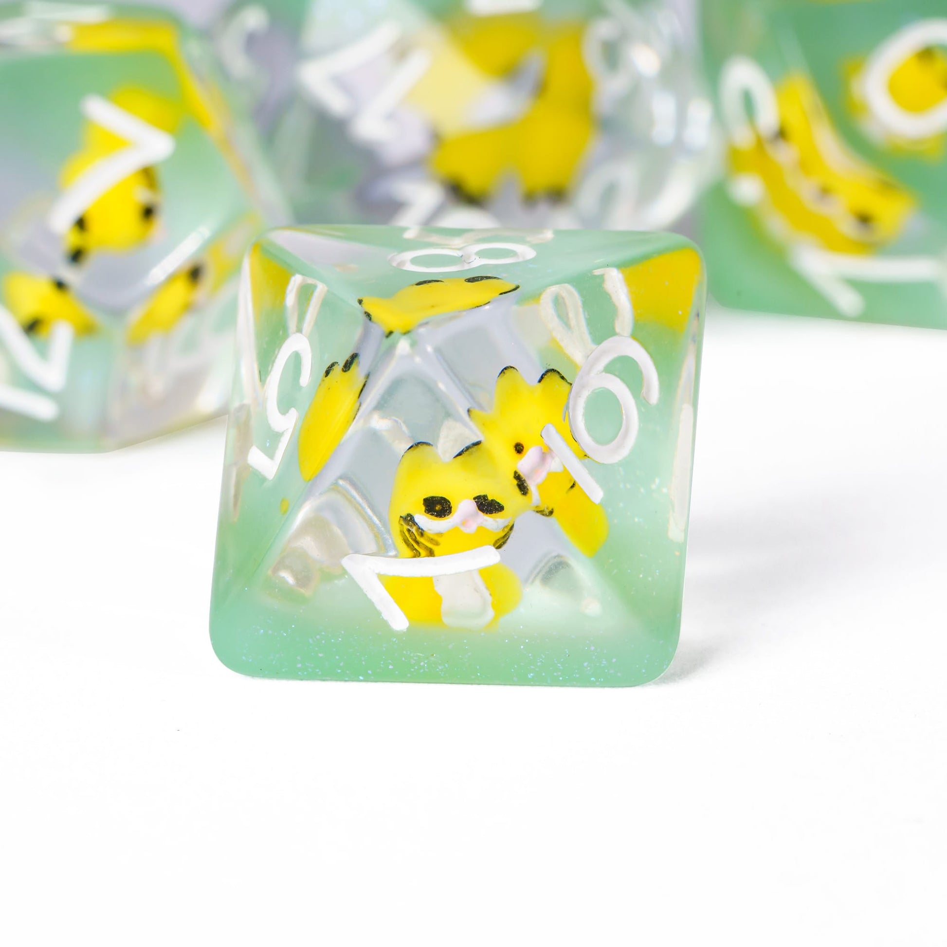 Transparent Yellow Cat D20 dice closeup with small yellow cat figure inside resin for tabletop RPG.