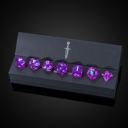 Violet Beam sharp edge dice displayed in black Only Crits box with sword logo, high-end TTRPG dice set