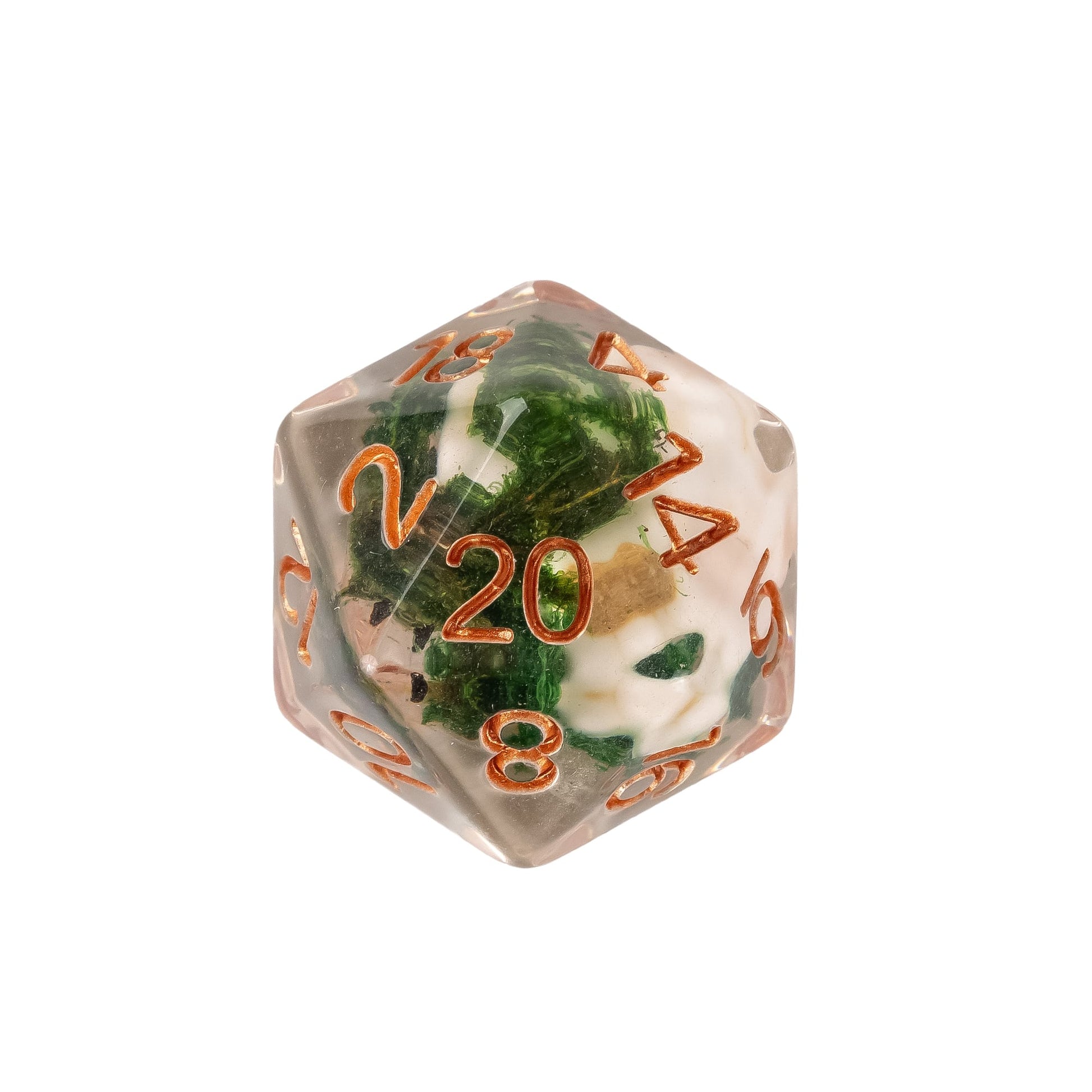 Close up of Wizards Soul Cage Skull Dice D20 featuring a skull inclusion suspended in clear resin with moss details and copper numbering