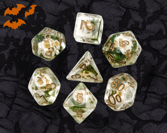 Wizards Soul Cage Skull DnD dice set in clear resin with tiny skulls, green moss accents and gold numbers
