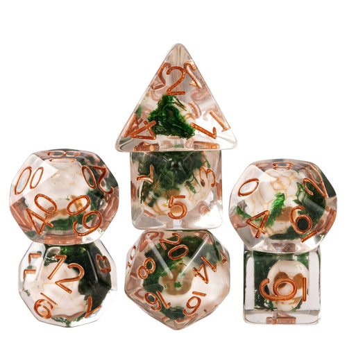 Stacked Wizards Soul Cage Skull dice set featuring skull inclusions suspended in clear resin with moss details and copper numbering