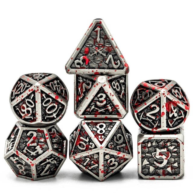 Dark grey and silver metal dice with blood spattered on them