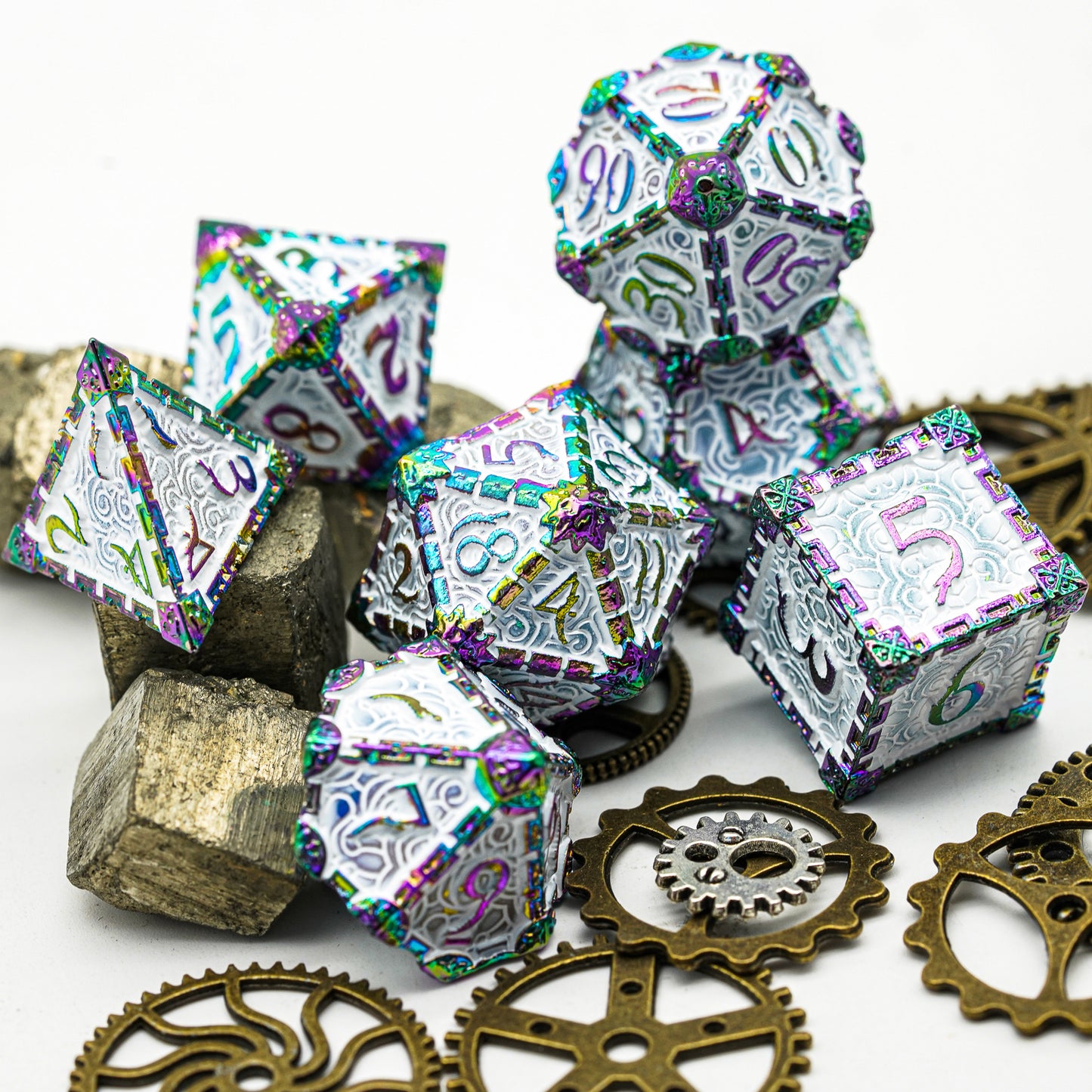 7 piece metal dagger dice set, snow blade, white and rainbow with gears and stones in foreground