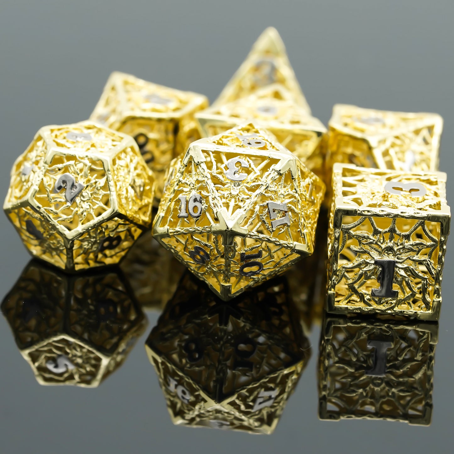 gold hollow metal dice set on black mirrored surface