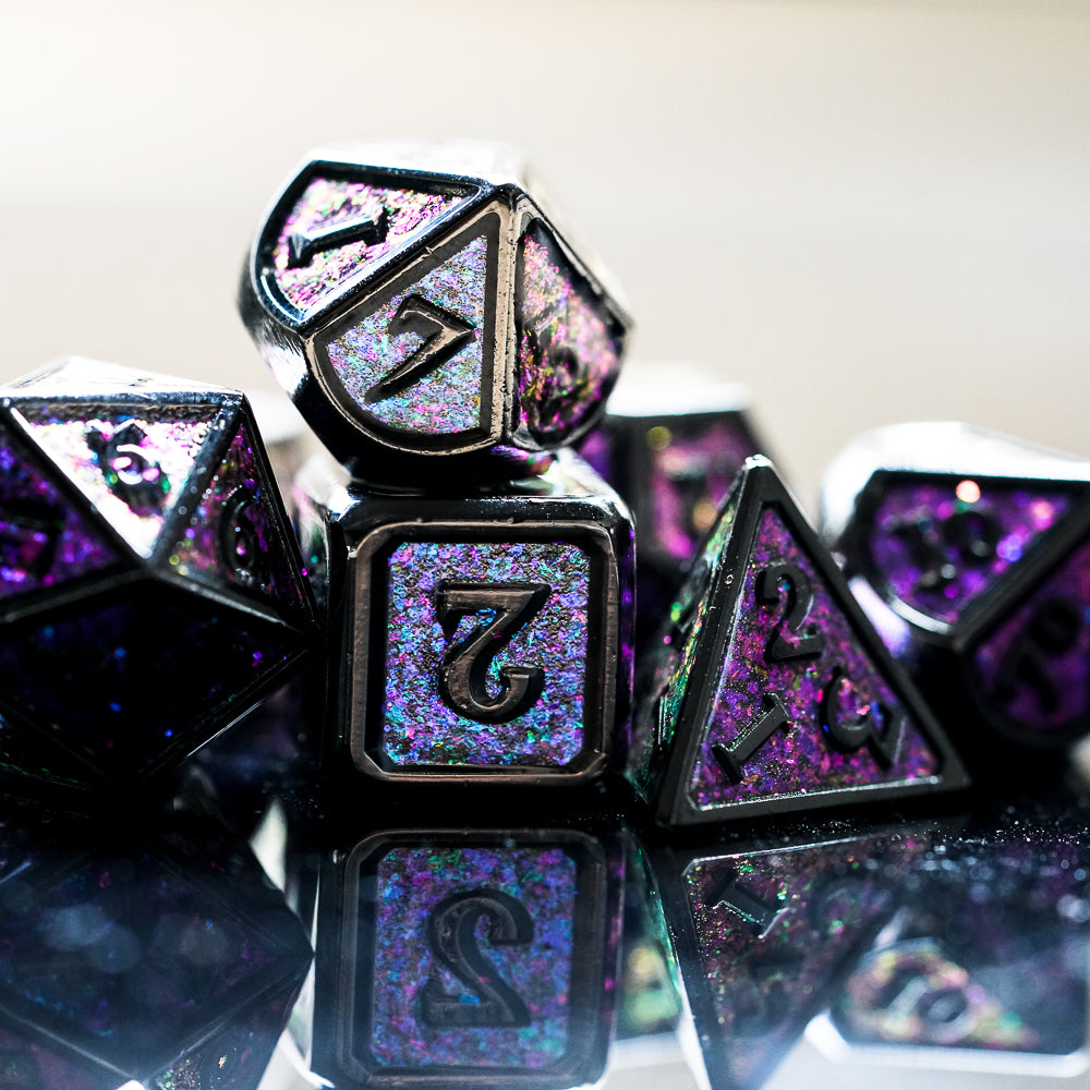purple and black metal dice set stacked on reflective dark surface