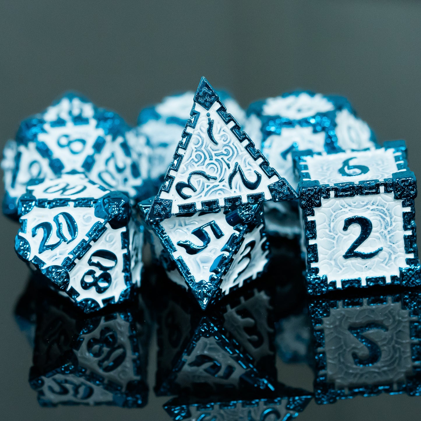 Metal Dice Set, 7 pieces, blue edges and numbers on white background, placed on reflective surface to show different angles 