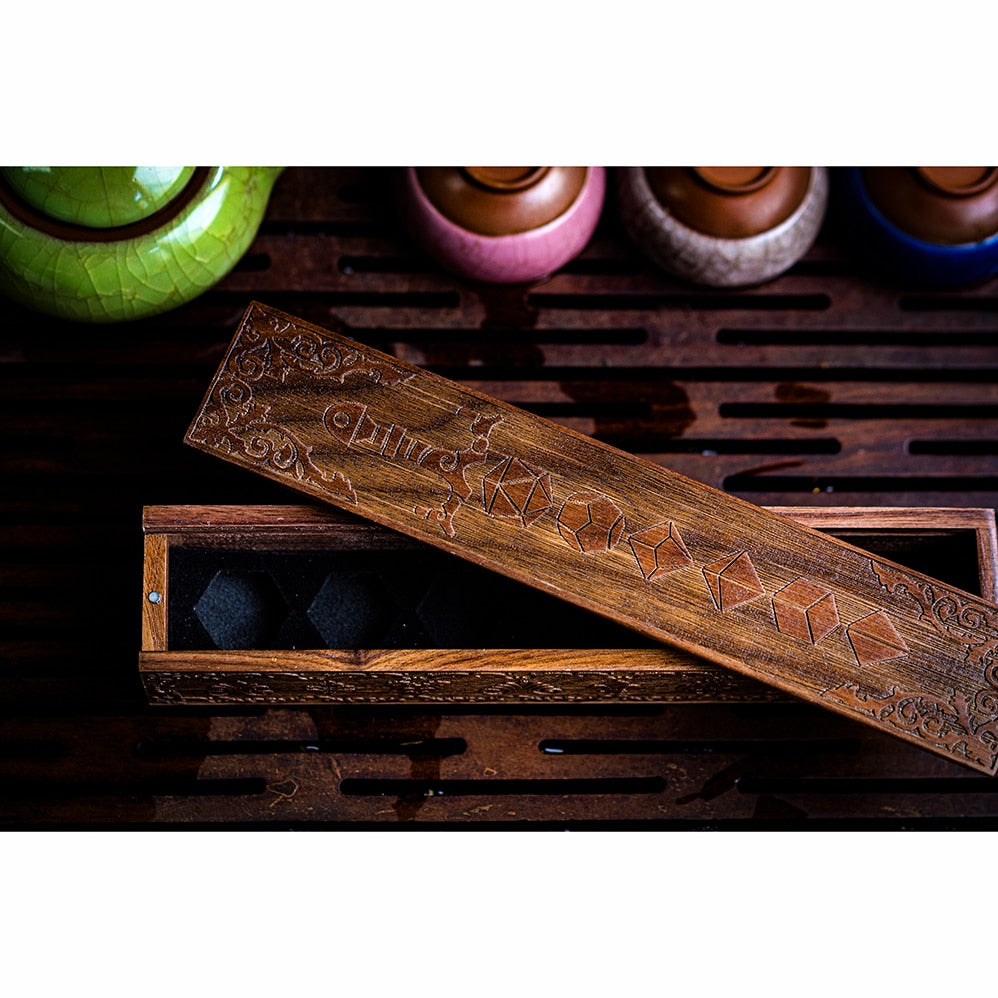 Close-up of engraved wooden lid with blade & dice pattern