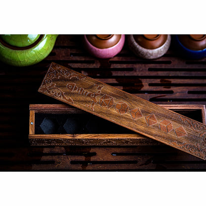 Close-up of engraved wooden lid with blade & dice pattern