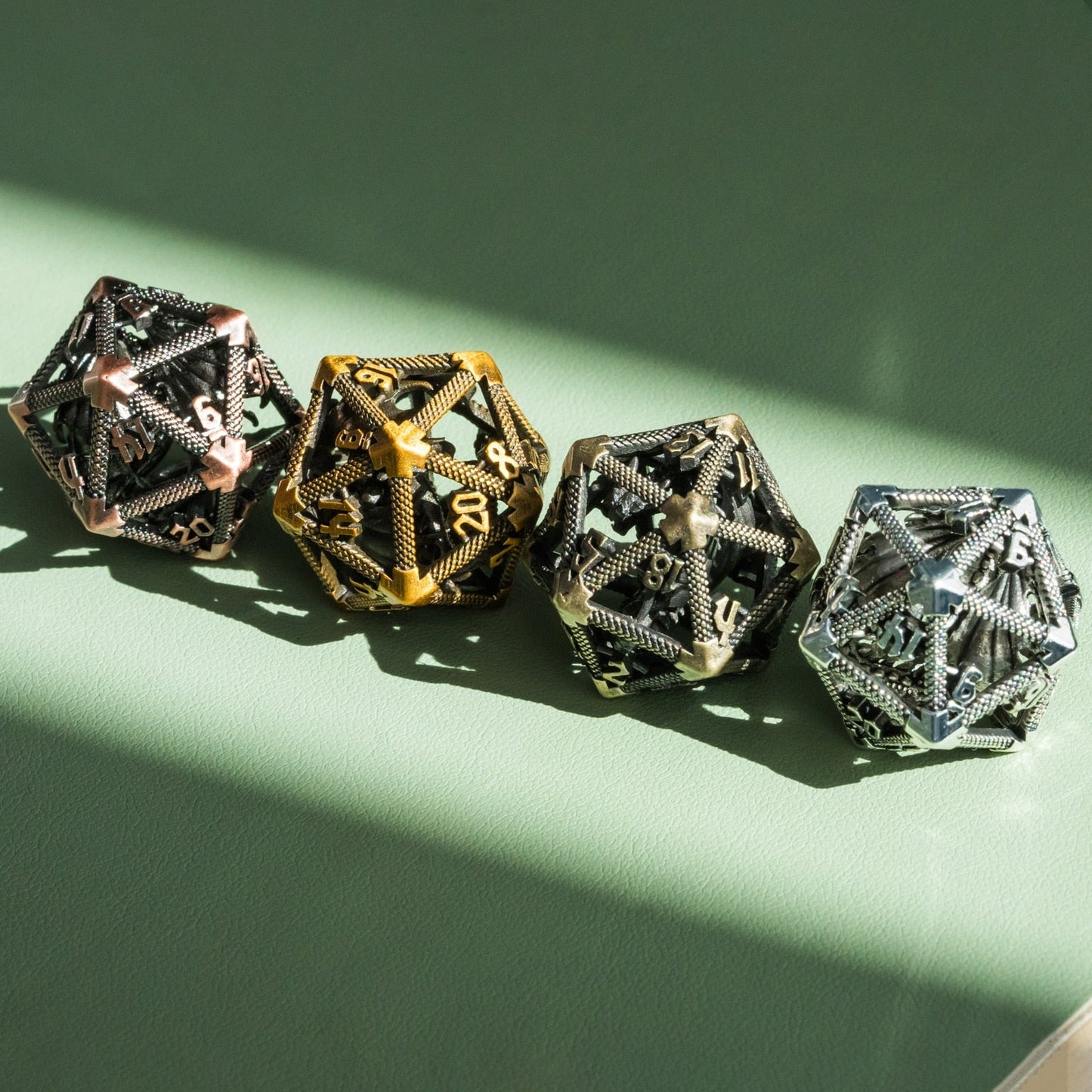 four hollow metal d20s in a beam of sunlight