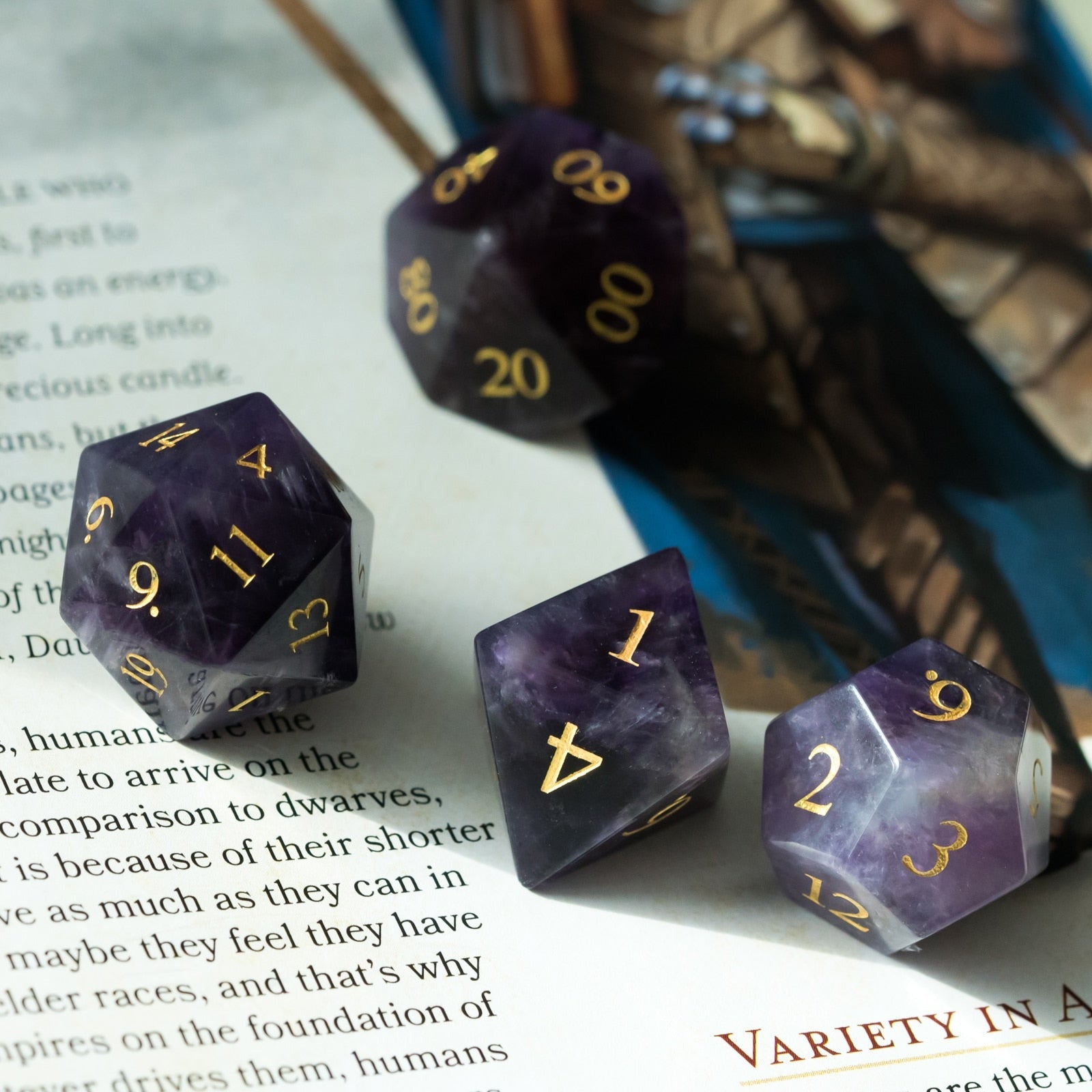 purple dnd stone dice sitting on player's handbook page