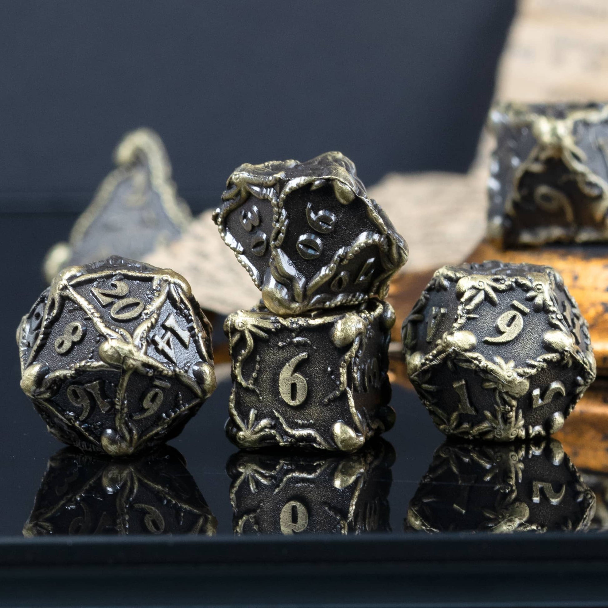 Light trimmed metal octopus dice, d20, percentage dice, d6 and d12 highlighted in front