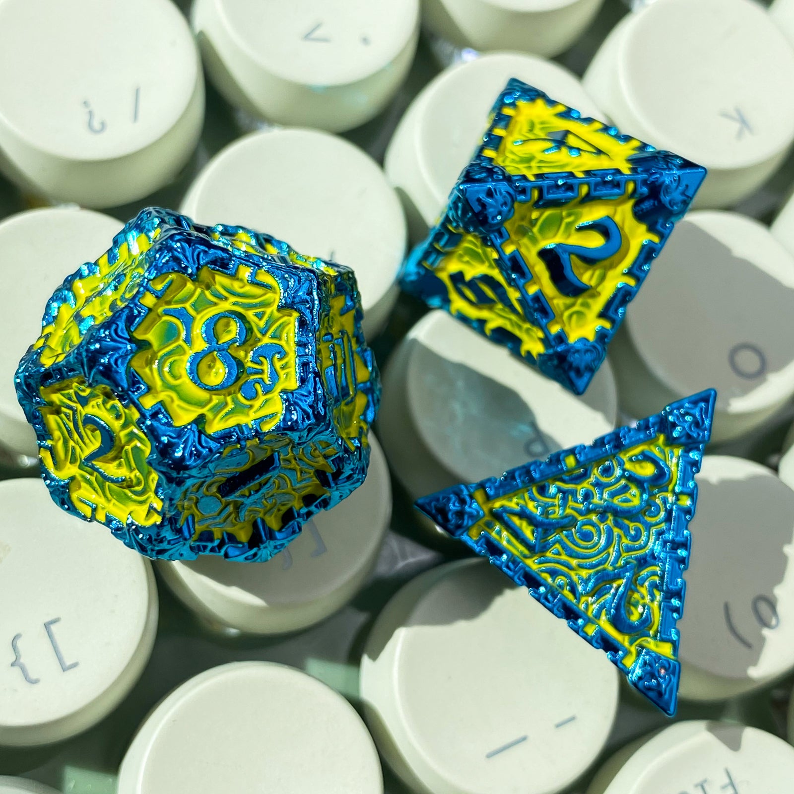 green metal dice with blue numbers and edges