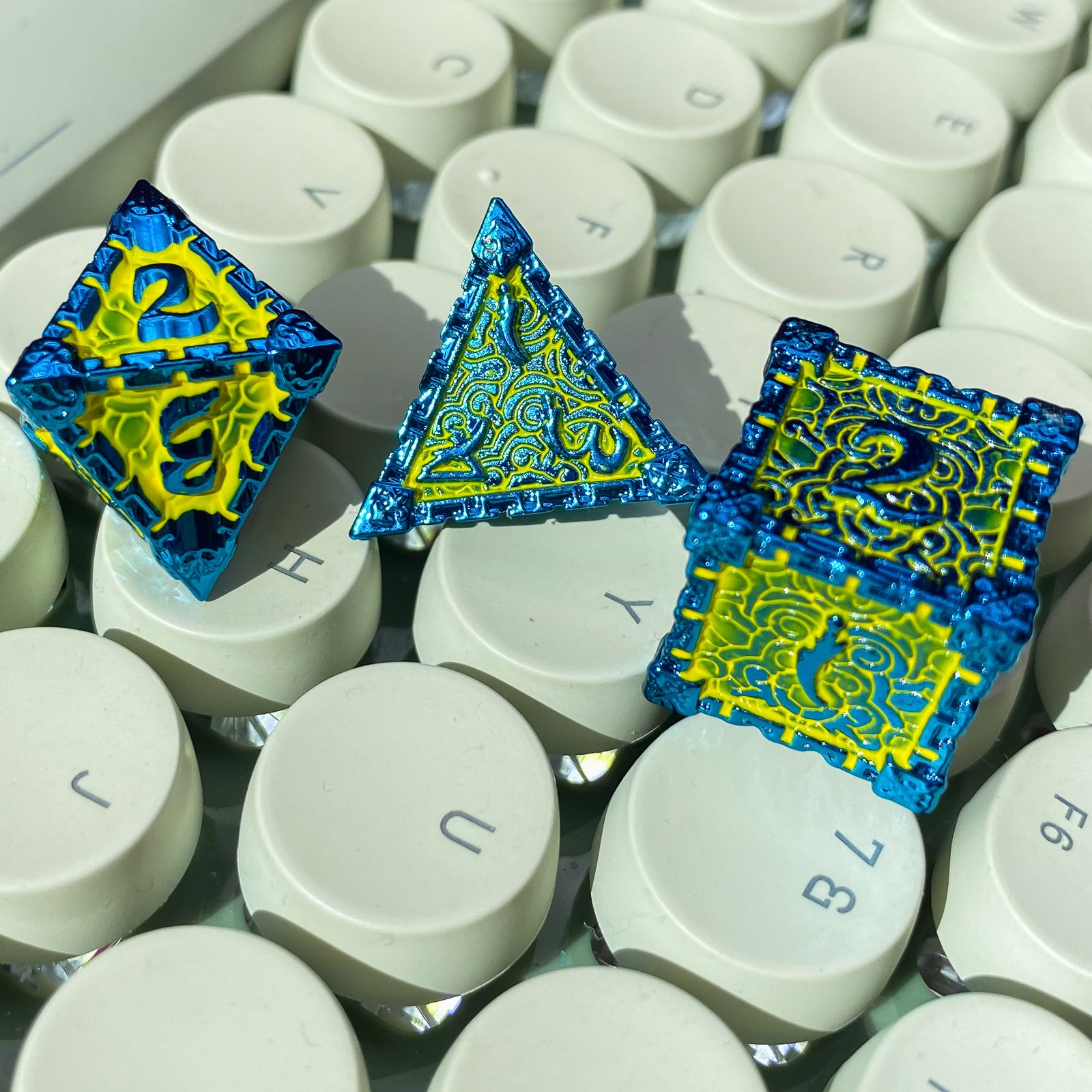 d6, d4 and d8 slime lord metal dice on white keyboard
