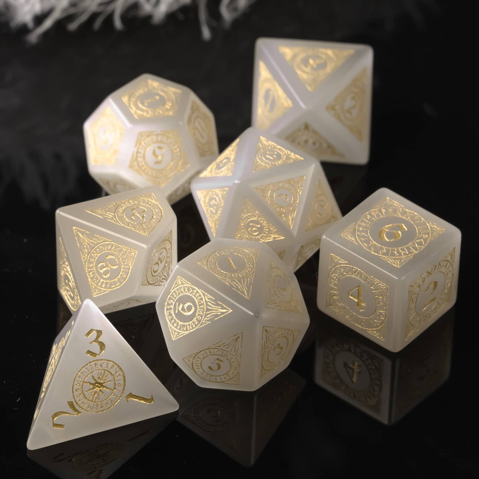 White stone dice set with gold numbers