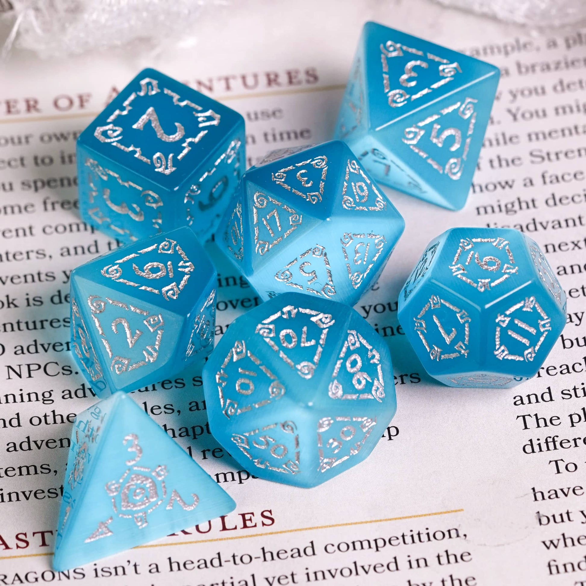 light blue stone dice set on player's handbook