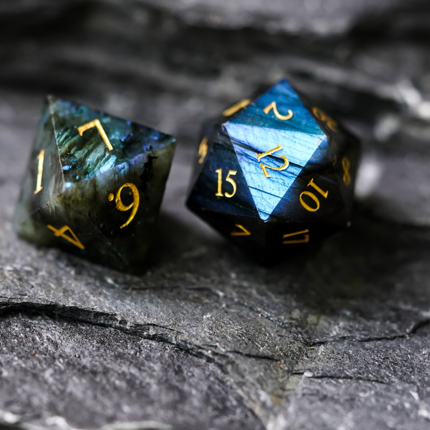 Labradorite Essence stone dice set close-up of two polyhedral dice with golden numbers