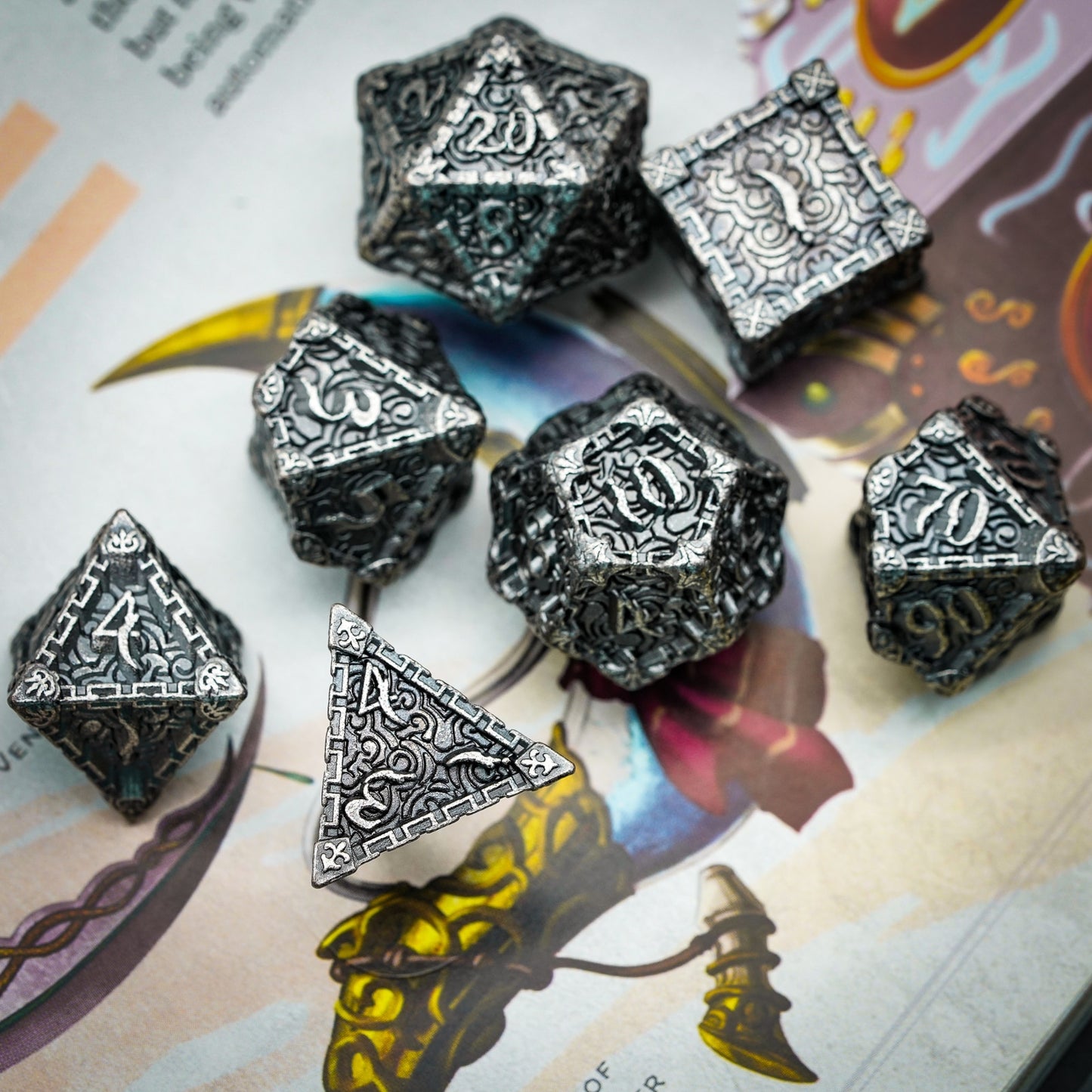 Silver metal dice set displayed on rulebook