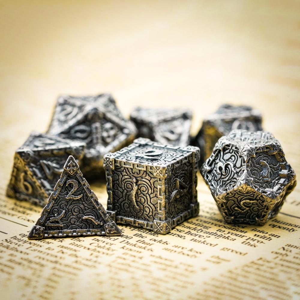 d6, d4 and d12 highlight, stone colored metal dice on book page