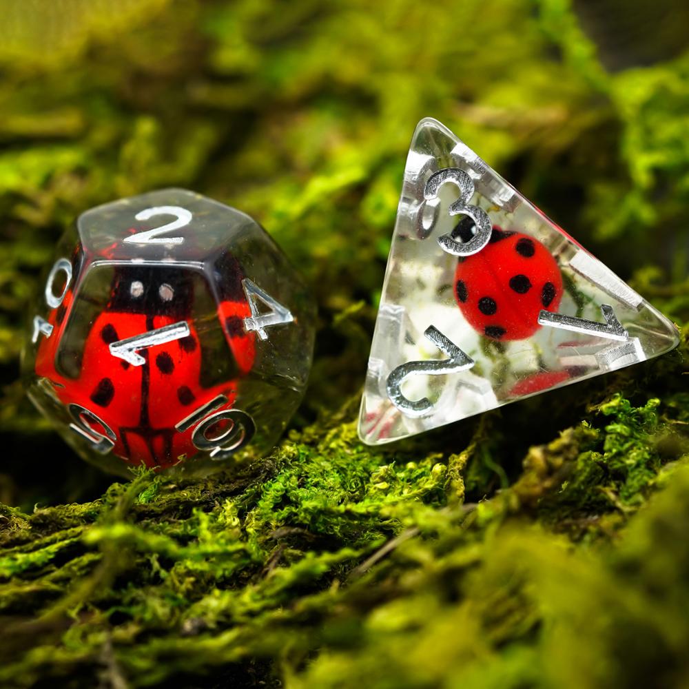 d12 and d4 highlight, clear resin, red ladybugs with white numbers on mossy backgdrop