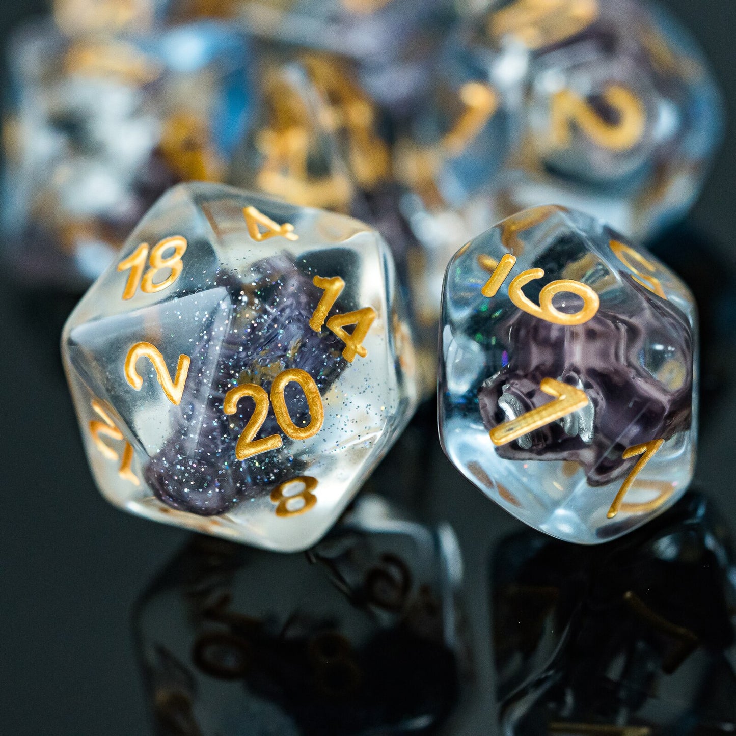 d20 and d10 highlight, sparkly resin with sailboat inside on black surface