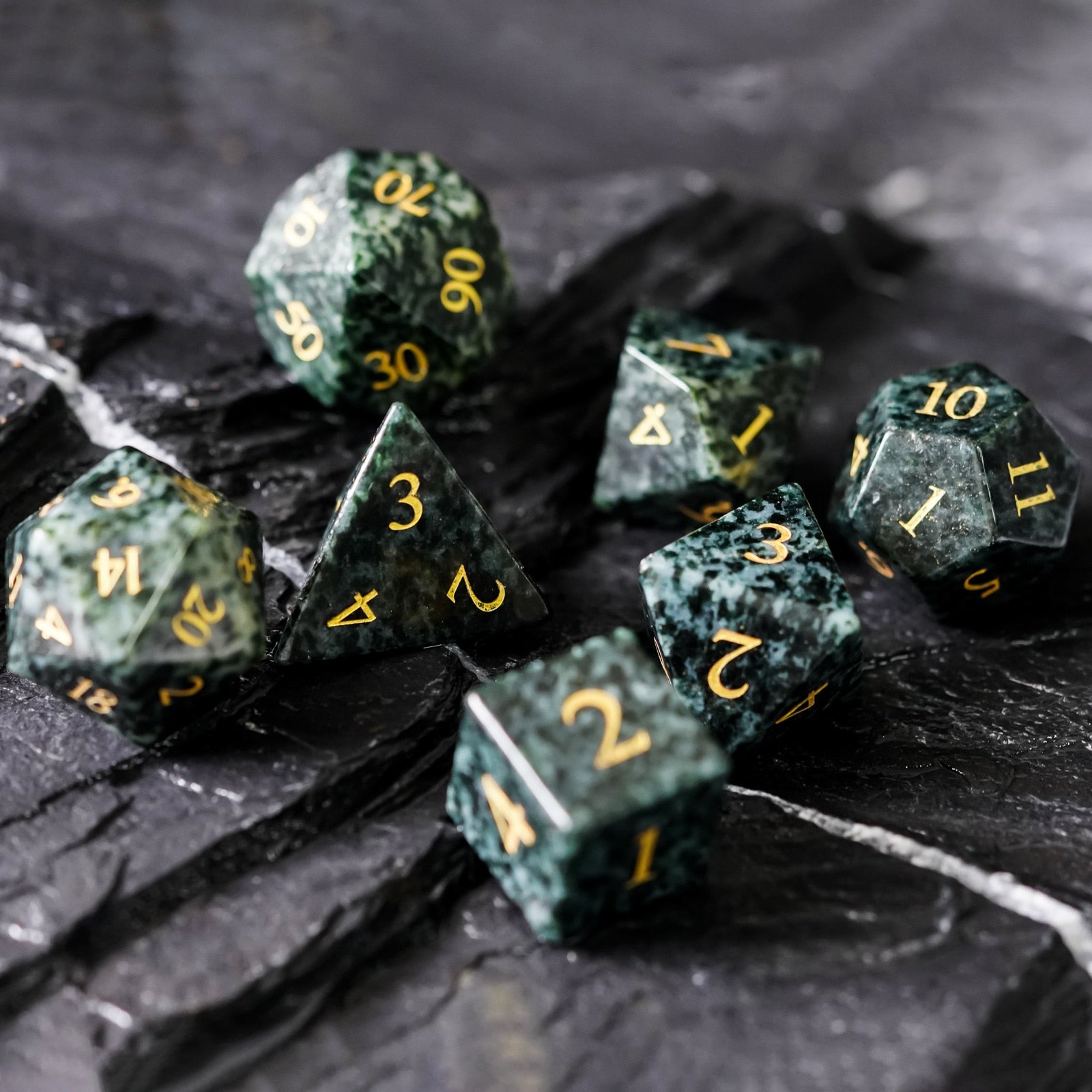 7 piece seaweed tangle stone dice set on obsidian background
