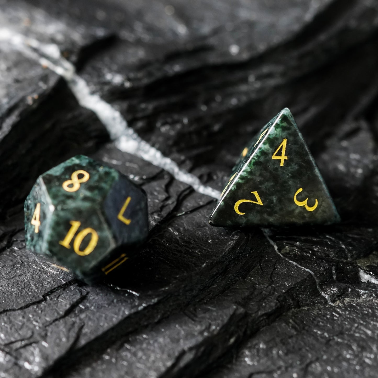 d12 and d4 stone dice, green and black with gold numbers