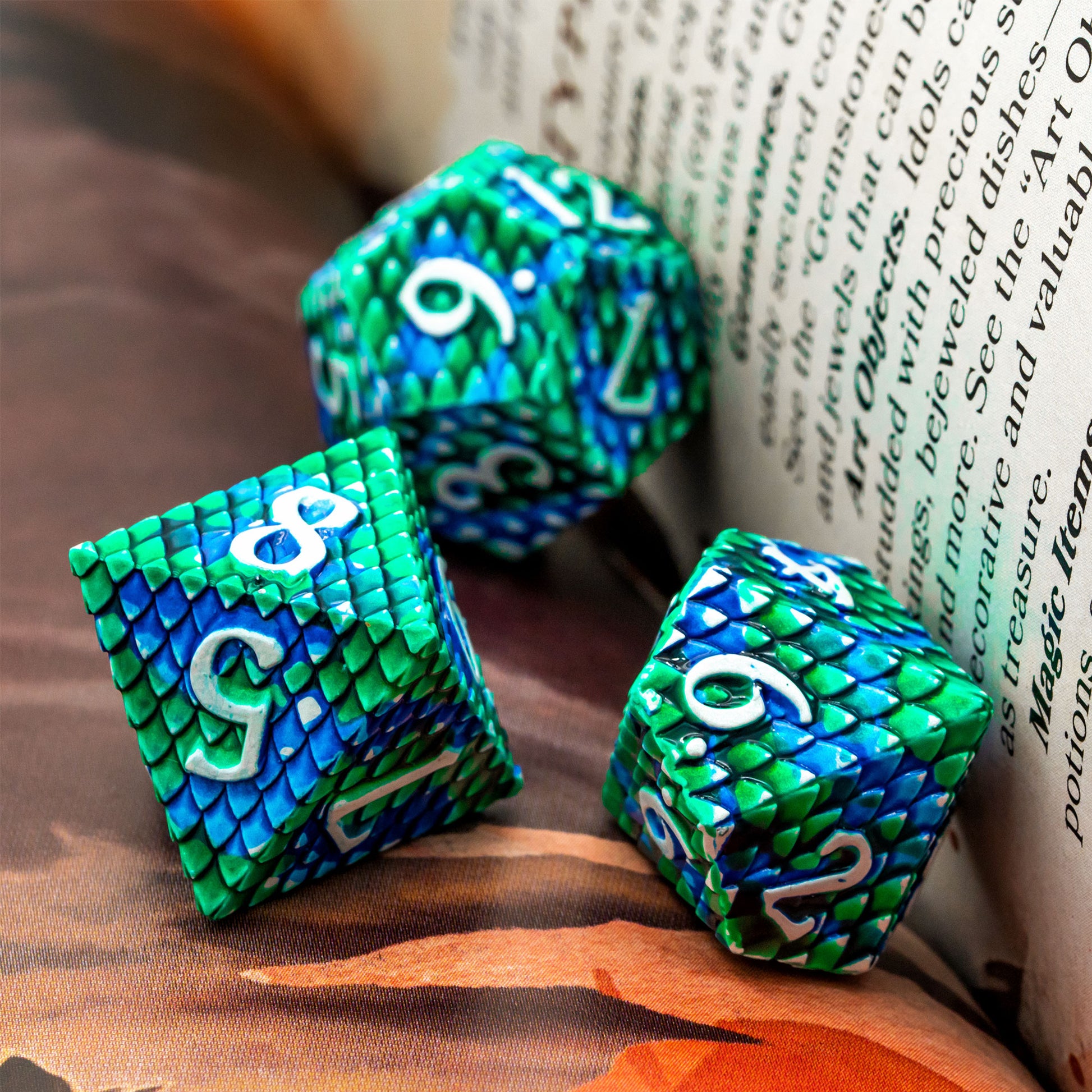 Blue and green dragon scale dice between sheets