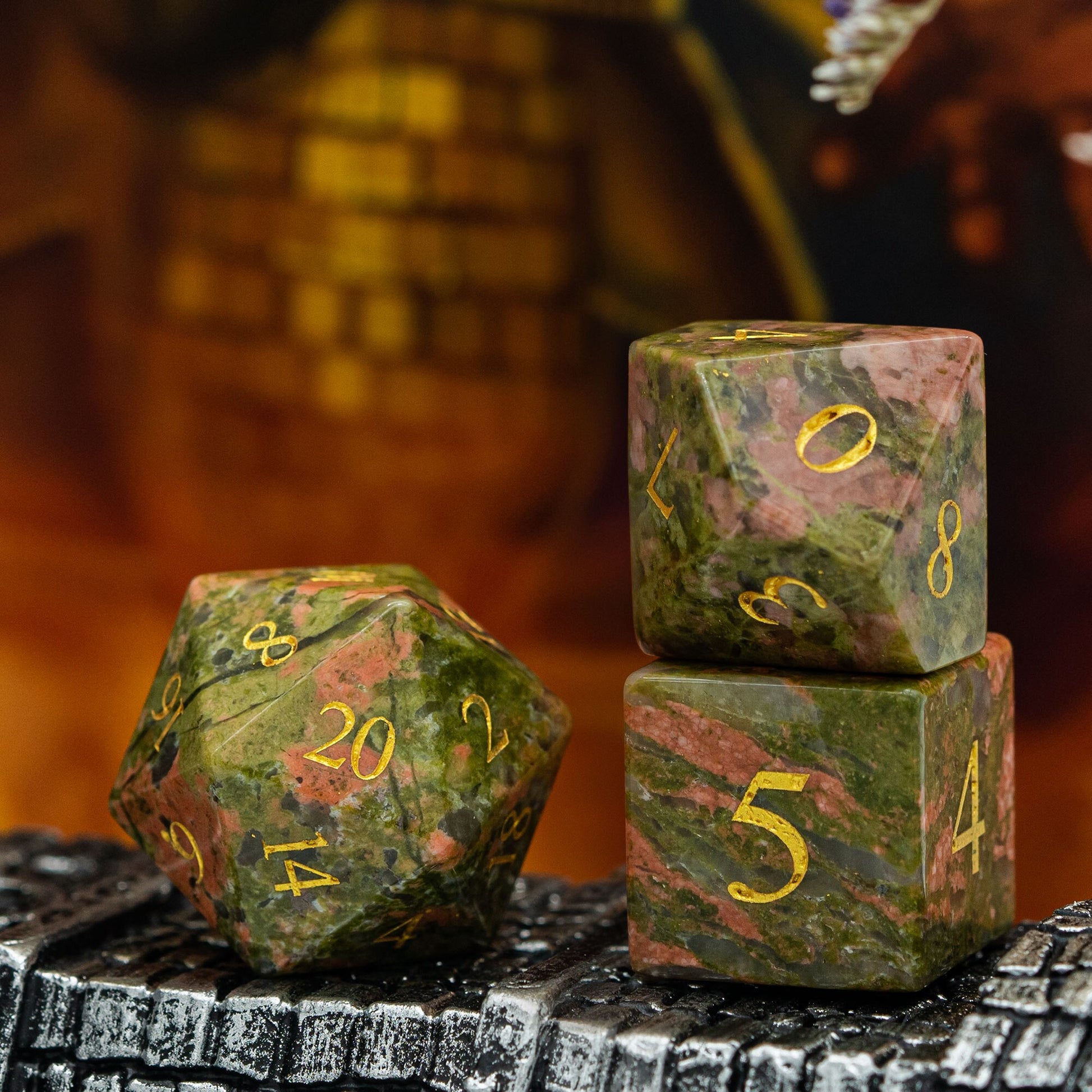  Close-up of Unakite Paste d20, d10,d6 stone dice set with pink and green stone texture
